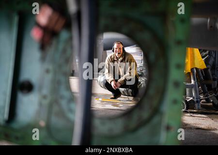 Senior Airman Nick Madson, 18. Equipment Maintenance Squadron Repair and Reclamation Journeyman, lacht, während er Wartungsarbeiten an einem F-15D Eagle am Kadena Air Base, Japan, am 25. Januar 2023 durchführt. Die Flugzeuge des 18. EMS unterstützen die Flugmission durch Munition, Flugzeuge und andere Wartungsarbeiten. Stockfoto