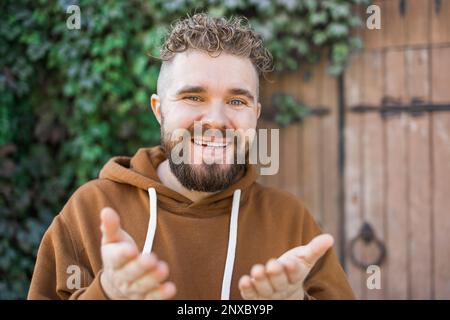 Ein hübscher, lockiger Mann nimmt ein Video von sich auf - Video-Blog und Jugend-Blogger-Konzept Stockfoto