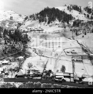 Arges County, Sozialistische Republik Rumänien, ca. 1975. Winterlandschaft mit kleinem Dorf in einer Bergregion. Stockfoto