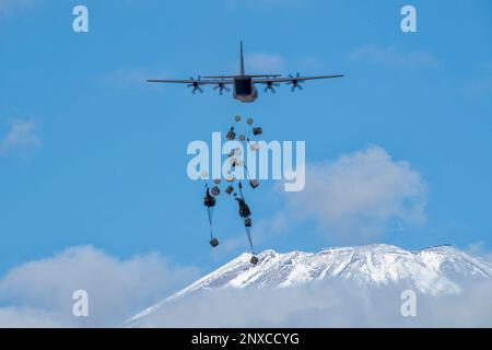 Die schweren Containersysteme (CDS) der japanischen Ground Self-Defense Force fallen aus den USA Air Force C-130J Super Hercules wurde der 36. Airlift-Geschwader im JGSDF East Fuji Manöver Area, Japan, am 31. Januar 2023 während der Airborne 23 zugeteilt. Neun C-130J-Flugzeuge, die der Yokota Air Base und der Little Rock Air Force Base, Arkansas, zugeteilt wurden, wurden verwendet, um während des Startsprungs-Teils der Übung etwa 300 JGSDF-Fallschirmjäger und CDS-Bündel in Abwurfzonen auf dem Higashi-Fuji-Trainingsfeld zu transportieren. Airborne 2023 ist ein groß angelegter Flugbetrieb, der Luft- und Bodenkräfte integriert Stockfoto