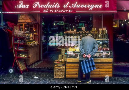 Ein Mann, der in einem Laden stöbert, der sich auf die Lebensmittel der Auvergne in der Rue Mouffetard, Paris spezialisiert hat. Stockfoto