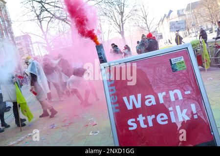 Hamburg, Deutschland. 01. März 2023. Teilnehmer eines landesweiten Jugendstreiks von Praktikanten und Doppelschülern im öffentlichen Sektor demonstrieren vor dem Gewerkschaftsgebäude. Ein roter Bengalo brennt auf einem Schild mit der Aufschrift „WARNING Strike“. In der aktuellen Runde der Tarifverhandlungen fordert Verdi eine Erhöhung der Lehrstellen- und Studentengehälter um 200 Euro pro Monat. Kredit: Bodo Marks/Bodo Marks/dpa/Alamy Live News Stockfoto