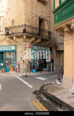 Valletta, Malta - 11. November 2022: Eckwarenladen für Baubedarf im Kalksteinhaus mit Balkon darüber Stockfoto