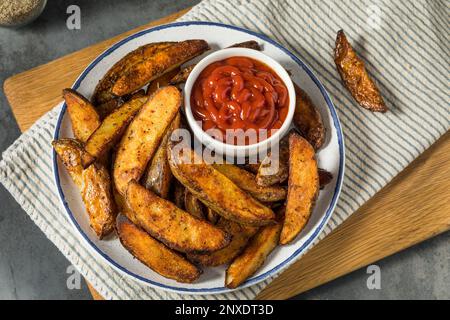 Hausgemachte Pommes frites mit Kartoffelkeil und Ketchup Stockfoto