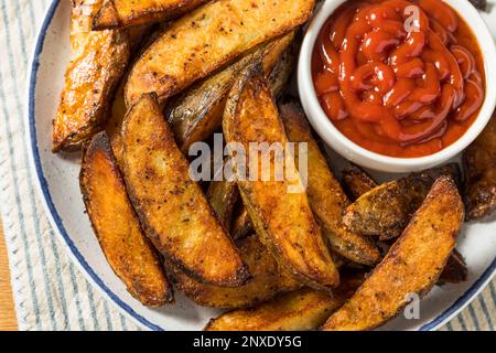 Hausgemachte Pommes frites mit Kartoffelkeil und Ketchup Stockfoto