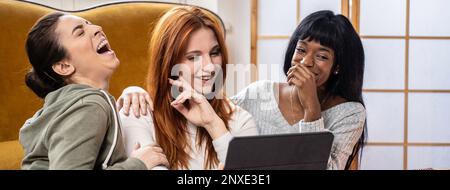 Horizontales Banner oder Kopfzeile mit fröhlichen multikulturellen weiblichen Freunden, die sich zu Hause in ihrer Freizeit aufhalten – Fröhliche junge Frauen beim Fernsehen Stockfoto