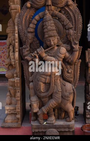 Holzkunst, Lord Krishna Idol aus Holz mit Handarbeit und gefüllt mit natürlichen Farben in Noida haat. Selektiver Fokus auf Objekt. Stockfoto