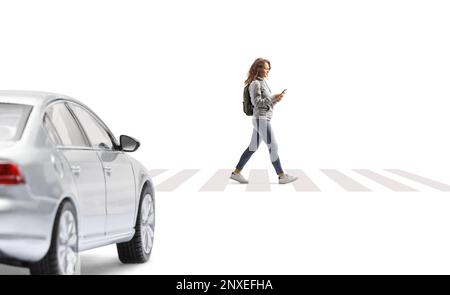 Das Auto fährt auf einen Fußgängerübergang zu und eine Studentin mit Smartphone läuft isoliert auf weißem Hintergrund Stockfoto