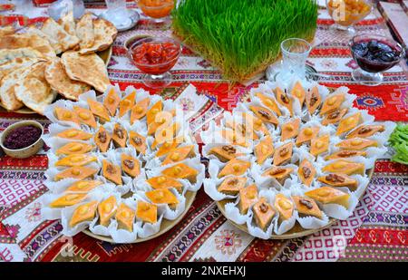 Traditionelle orientalische Süßigkeiten, Baklava, Kuchen, Marmelade auf Tellern auf einem Tisch. Mahlzeiten werden während des großen islamischen Urlaubs in Nowruz serviert. Stockfoto
