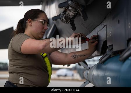 Ein Flugmann, der der 336. Kampfeinheit zugeteilt wurde, zieht eine Schraube an einem F-15E Strike Eagle während des 4. Quarter Weapons Load Crew Wettbewerbs am Seymour Johnson Air Force Base, North Carolina, 13. Januar 2023 an. Die Besatzungen waren dafür verantwortlich, dass die Munition sicher, richtig konfiguriert und einsatzfähig war. Stockfoto