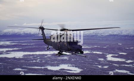 Alaska Air National Guardsmen mit dem 210. Rettungsgeschwader manövrieren einen HH-60G Pave Hawk Helikopter über das Lower Susitna Valley bei Anchorage, Alaska, 7. Februar 2023. Die HH-60G ist zusammen mit dem 211. RQS HC-130J Combat King II-Flugzeug und Rettungspersonal aus dem 212. RQS alarmiert für die Such- und Rettungsmission des Bundes in der riesigen arktischen Region Alaska. Die Luftbetankungskapazität des HC-130F erweitert das Angebot des HH-60G Pave Hawk für Such- und Bergungsmissionen erheblich. Stockfoto