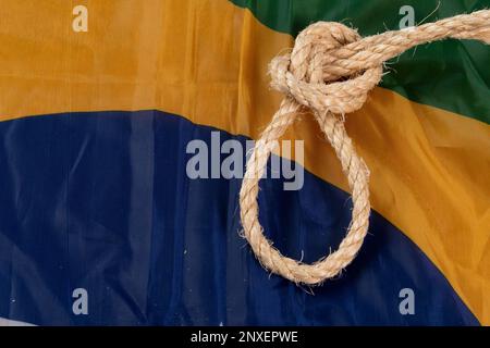 Seil mit einer Schlinge über die brasilianische Flagge, die die Sklaverei im Land symbolisiert Stockfoto