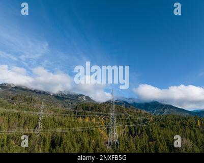 Ansicht der Hochspannungsleitung 110kV in der Mitte des Waldes auf großen Metallpylonen für den Langstreckentransport von Energie Stockfoto