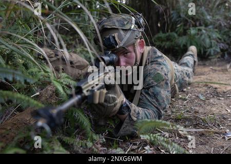 USA David Bibby, ein Maschinengewehrer mit 1. Bataillonen, 2. Marines, 3D Marine Division, bietet Sicherheit während eines Mannschaftswettbewerbs im Jungle Warfare Training Center in Camp Gonsalves, Okinawa, Japan, am 26. Januar 2023. Der Squad-Wettbewerb ist ein einwöchiger Wettbewerb, bei dem die Fähigkeiten der Mannschaften des Marine Corps in Bezug auf ihre Kampffähigkeiten auf die Probe gestellt werden. Bibby stammt aus Elyrien. Stockfoto