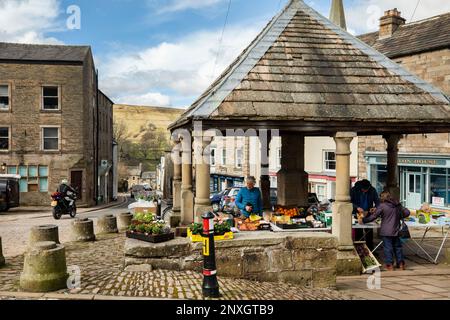 Sie verkaufen Obst und Gemüse vom alten Market Cross in Alston, der höchsten Stadt Englands, Cumbria, North Pennines Stockfoto