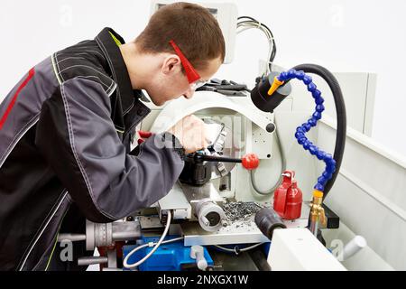 Arbeiter bearbeitet Metall an der Drehmaschine Stockfoto