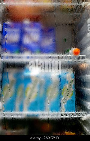 Nahaufnahme von Wassertropfen auf dem Glas des Kühlschranks. Kondensationsbedingungen des Wassers in der Luft, die zu verschwommenen Wassertropfen führen. Stockfoto