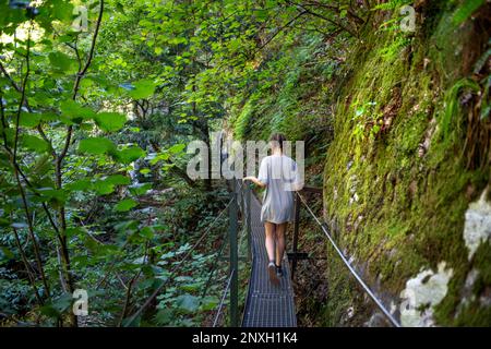 Wandern über eine Metallbrücke auf einem Wanderweg durch Gorges de la Carancala, Pyrénées-Orientales, Languedoc-Roussillon, Frankreich. Die Carançà G Stockfoto