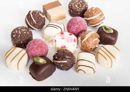 Schokoladenpralinen Trüffel. Auswahl an runden Trüffeln als Geburtstagsgeschenk. Luxuriöse Süßigkeiten im weißen Hintergrund. Auswahl an farbenfrohen Stockfoto