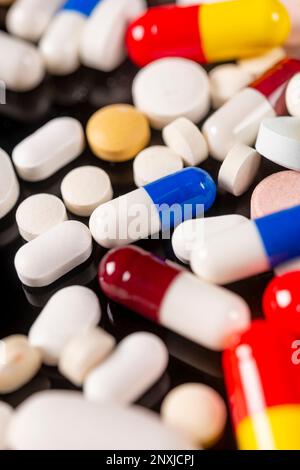 Farbige Pillen auf schwarzem Hintergrund Stockfoto