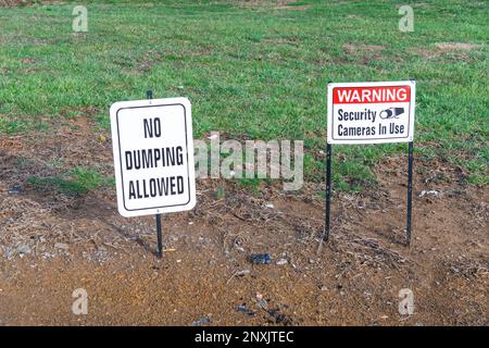 Horizontale Aufnahme eines Hinweises „kein Ablegen zulässig“ und eines Hinweises „Warnung Sicherheitskameras in Verwendung“ in einem Feld. Stockfoto