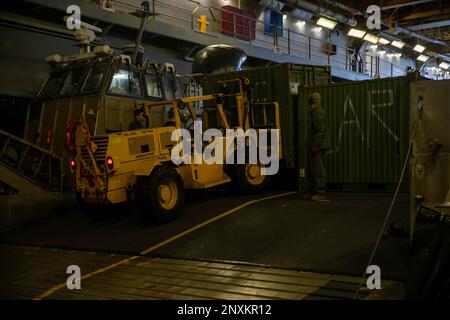 230203-N-VO895-1026 ATLANTISCHER OZEAN (3. Februar 2023) Amphibienschiff der Wasp-Klasse USS Bataan (LHD 5) Seeleute und Marines transportieren 26. Ausrüstung der Marine Expeditionary Unit (26. MEU) vom Schiff auf ein Luftpolster (LCAC), das der Assault Craft Unit 4 zugewiesen ist, 3. Februar 2023. Die USS Bataan, das Amphibiengeschwader 8 (PHIBRON) und das 26.-MEU, die alle Teil der Bataan Amphibious Readiness Group (BATARG) sind, nehmen derzeit an einer PHIBRON-MEU Integrated Training (PMINT)-Übung Teil. Stockfoto