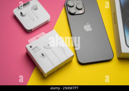 Neue iPhone 14 pro max und Apple Ohrhörer, AirPods weiße Ohrhörer in einer offenen Box. Isolierter, farbenfroher Hintergrund. Stockfoto