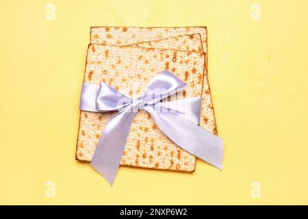 Jüdisches Fladenbrot Matza für Pessar mit Band auf gelbem Hintergrund Stockfoto