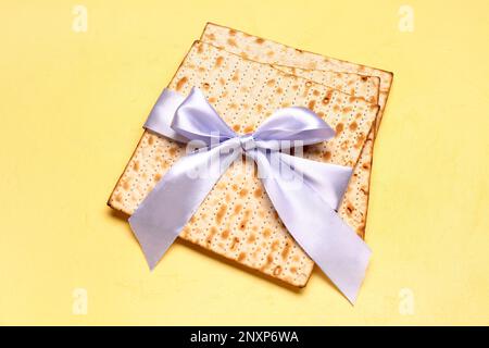 Jüdisches Fladenbrot Matza für Pessar mit Band auf gelbem Hintergrund Stockfoto