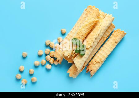 Köstliche Waffeln, Haselnüsse und Minze auf blauem Hintergrund Stockfoto