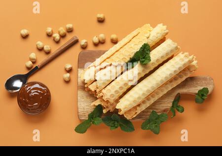 Gehen Sie an Bord mit köstlichen Waffeln, gekochter Kondensmilch, Haselnüssen und Minze auf braunem Hintergrund Stockfoto