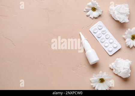 Nasentropfen mit Pillen, Blumen und Taschentüchern auf beigefarbenem Hintergrund. Saisonales Allergiekonzept Stockfoto