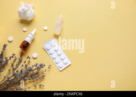Tropfenflaschen mit Pillen, Blumen und Taschentüchern auf gelbem Hintergrund. Saisonales Allergiekonzept Stockfoto
