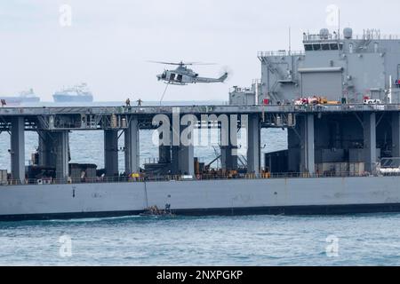 NATUNA SEA (7. Januar 2023) – Marines, die einem Marine-RAID-Force-Zug (MRF) zugeteilt sind, an Bord der Amphibien-Transportanlage USS Anchorage (LPD 23) Verwenden Sie 11m aufblasbare Boote mit starrem Rumpf (RHIBs) und ein UH-1Y-Gift, das dem variablen Tiltrotor-Geschwader (VMM) 362 zugewiesen ist, um an Bord eines Lewis B. Puller-Class Expeditionary Mobile Base USS Miguel Keith (ESB 5) zu gehen, um am 7. Januar eine Schulung für Visit, Board, Search, and seizure (VBSS) durchzuführen. Die Fähigkeit, nahtlos und gleichzeitig auf See, an Land und in der Luft zu arbeiten, stellt den einzigartigen Wert der amphibischen Fähigkeiten dar, die das ARG/MEU-Team bietet. Der Makin Ist Stockfoto