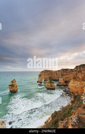 Landschaft an der Algarve bei Sonnenuntergang. Strand im Süden Portugals das beste Reiseziel für Touristen im Urlaub. seascape mit Höhlen durch Stockfoto