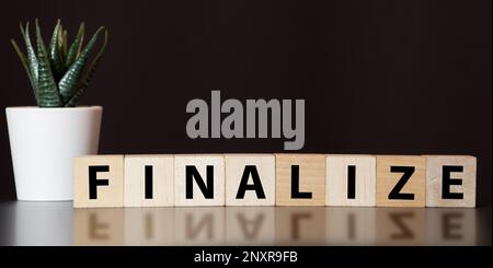 Holzwürfel mit Word FINAL auf dem Schreibtisch. Ordner und andere Büromaterialien. Arbeitsplatz. Stockfoto