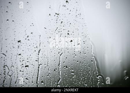 Regentropfen auf einem Fenster Schmerzen an einem düsteren grauen Regentag Stockfoto
