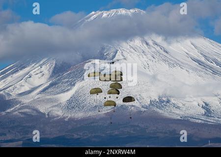 Die schweren Containersysteme (CDS) der japanischen Ground Self-Defense Force fallen aus den USA Air Force C-130J Super Hercules wurde der 36. Airlift-Geschwader im JGSDF East Fuji Manöver Area, Japan, am 31. Januar 2023 während der Airborne 23 zugeteilt. Neun C-130J-Flugzeuge, die der Yokota Air Base und der Little Rock Air Force Base, Arkansas, zugeteilt wurden, wurden verwendet, um während des Startsprungs-Teils der Übung etwa 300 JGSDF-Fallschirmjäger und CDS-Bündel in Abwurfzonen auf dem Higashi-Fuji-Trainingsfeld zu transportieren. Airborne 2023 ist ein groß angelegter Flugbetrieb, der Luft- und Bodenkräfte integriert Stockfoto