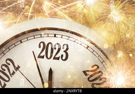 Uhr zählt die letzten Momente bis zum Neuen 2023. Jahr und wunderschönes Feuerwerk im Hintergrund Stockfoto
