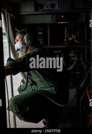 Ein Mitglied der Japan Air Self-Defense Force (JASDF) schaut vor dem Abflug von Tinian, Nördliche Marianen, aus der Tür eines C-130H Hercules, während einer Tour durch das Rathaus am 7. Februar 2023. Drei Sportdirektoren von JASDF, Royal Australian Air Force und U.S. Die Luftwaffe besuchte die Inseln Saipan, Tinian und Rota, um mit Gemeindeführern über lokale Bedürfnisse und Anliegen zu sprechen, und betonte dabei das Ziel, Partnerschaften aufzubauen, bevor Cope North 23 umgesetzt wird. Stockfoto