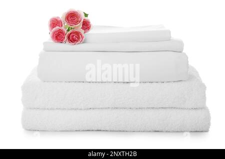 Ein Stapel Handtücher und Bettlaken mit Rosen auf weißem Hintergrund Stockfoto