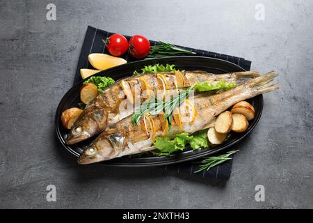 Leckere hausgemachte, geröstete Hecht-Sitzstangen serviert auf einem grauen Tisch, Blick von oben. Flussfische Stockfoto