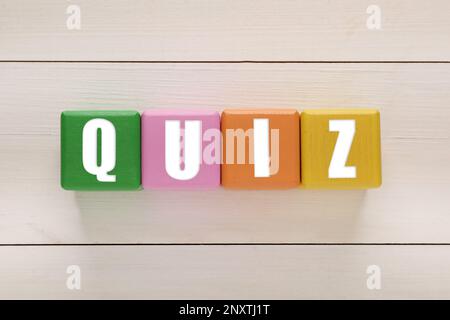 Bunte Würfel mit Wort Quiz auf weißem Holztisch, flach liegend Stockfoto