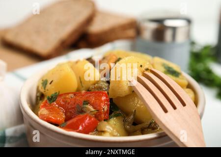 Leckeres gekochtes Gericht mit Kartoffeln in Steingut, Nahaufnahme Stockfoto