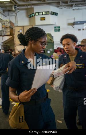 230126-N-KU796-1054 SÜDCHINESISCHES MEER (26. JANUAR 2023) USA Navy Machinist's Mate 3. Class Kierra Jackson aus Nashville, Tennessee, organisiert Post in der Hangarbucht an Bord des Flugzeugträgers USS Nimitz (CVN 68). Nimitz ist in der US-7.-Flotte und führt Routineeinsätze durch. 7. Fleet sind die USA Die größte Flotte der Navy, die mit einer Anzahl von Flotten ausgestattet ist, und arbeitet regelmäßig mit Alliierten und Partnern zusammen, um eine freie und offene Region im Indo-Pazifik zu erhalten. Stockfoto