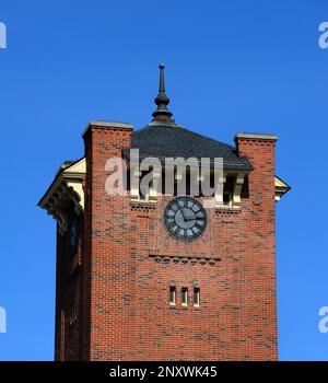 Das historische Clinchfield Railroad Depot, der Uhrenturm, ist aus rotem Ziegelstein und vom blauen Himmel eingerahmt. Stockfoto