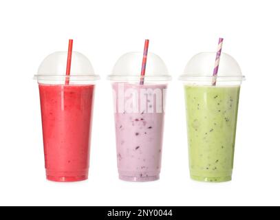 Verschiedene Smoothies mit Pailletten in Kunststoffbechern auf weißem Hintergrund Stockfoto