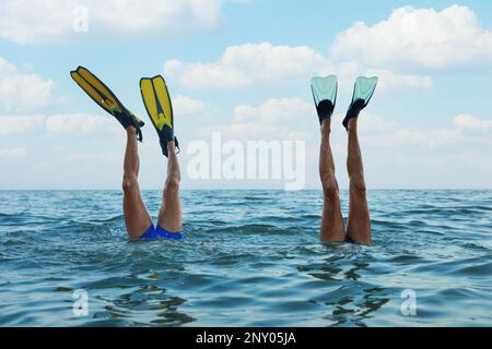 Männer in Flossen tauchen ins Meerwasser Stockfoto