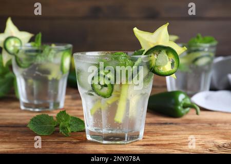 Würziger Cocktail mit Jalapeno, Karambola und Minze auf einem Holztisch Stockfoto