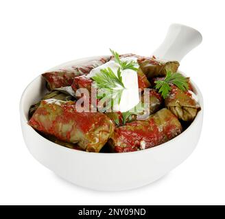 Köstliche gefüllte Traubenblätter mit saurer Sahne und Tomatensoße auf weißem Hintergrund Stockfoto